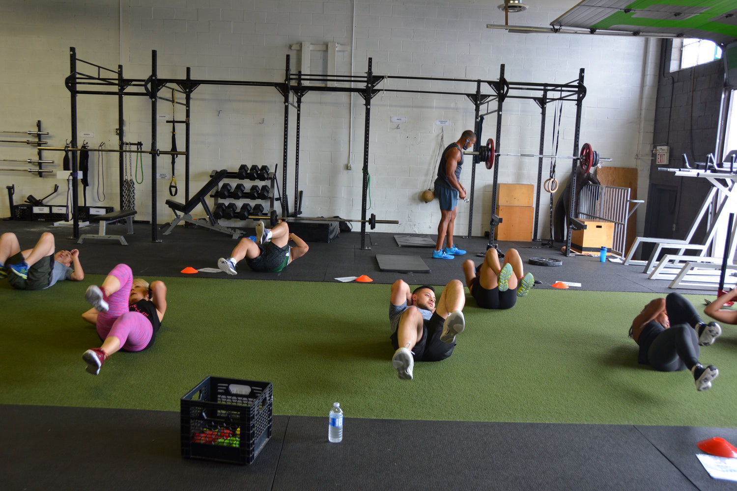 "Group of fitness enthusiasts performing bicycle abs exercise during a group fitness class, aimed at strengthening the abdominal muscles and improving core stability.